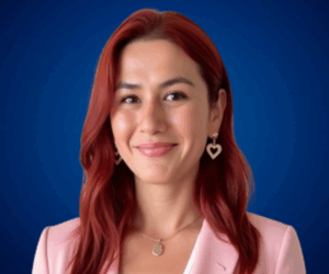 Retrato profesional de Yera Flores con fondo azul.