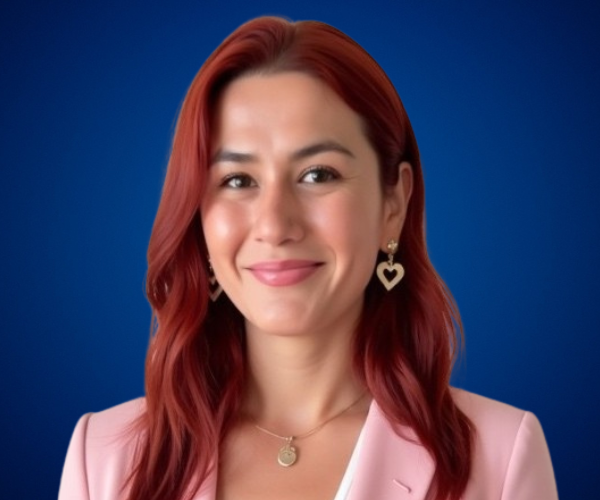 Retrato profesional de Yera Flores con fondo azul.