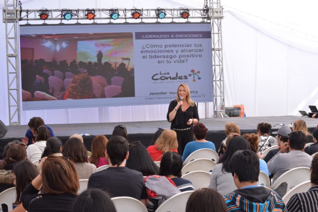 Jennifer Warner impartiendo conferencia sobre liderazgo y emociones frente a público atento