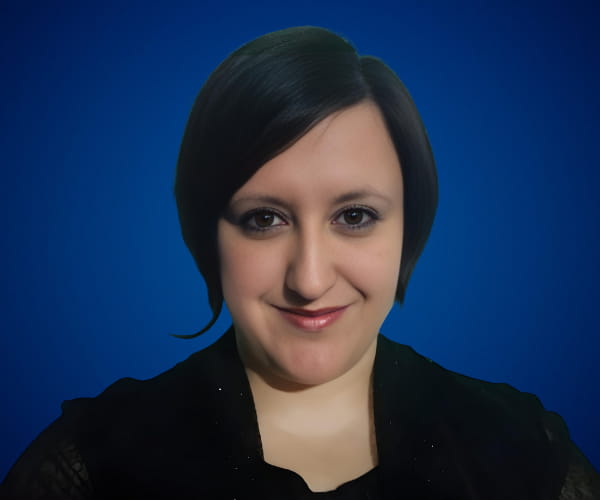 Fotografía de Cecilia Frontera con fondo azul, luciendo una expresión amigable y profesional en un retrato de primer plano.