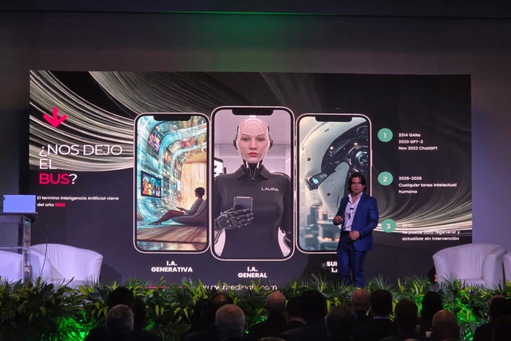 Fotografía de Alejandro Medina presentando en un congreso sobre inteligencia artificial, frente a una pantalla con imágenes futuristas de IA generativa, general y superinteligencia.