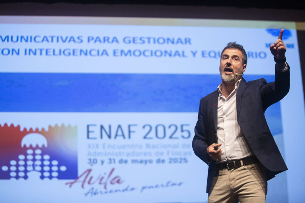 Fotografía de Zacarías Romero durante su conferencia en el XIX Encuentro Nacional de Administradores de Fincas (ENAF 2025) en Ávila, gesticulando con energía frente a una pantalla con el tema de inteligencia emocional y equilibrio.