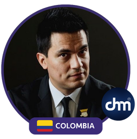 Fotografía de Germán Arciniegas en retrato formal, con fondo oscuro, bandera de Colombia y logotipo de Charlas Motivacionales Latinoamérica.