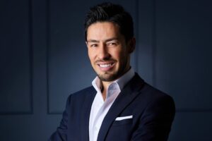 Sergio Nava experto en liderazgo empresarial posando con traje elegante para su conferencia motivacional.