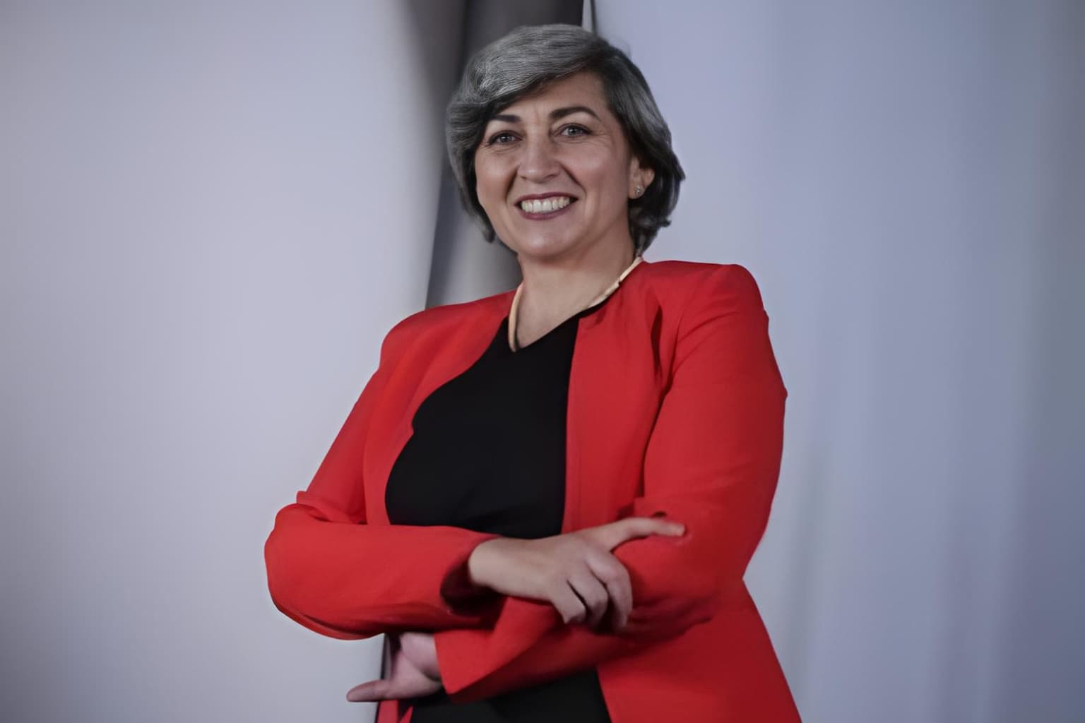 Beatriz Ramírez posando con una sonrisa segura, vestida con saco rojo, demostrando su liderazgo y compromiso.