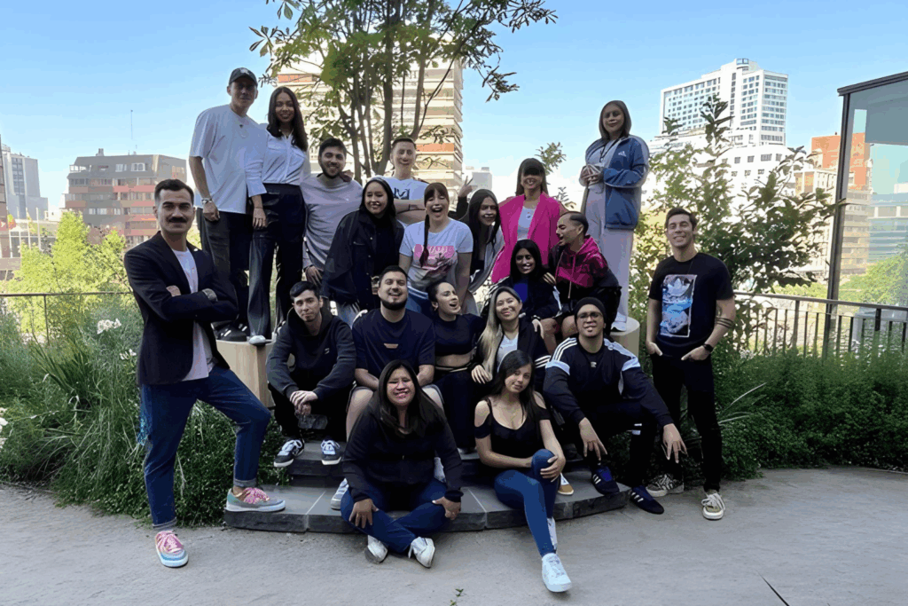 Fotografía de Octavio Díaz Matus junto a un grupo de jóvenes en un espacio al aire libre, con fondo urbano y áreas verdes, transmitiendo unión y colaboración.