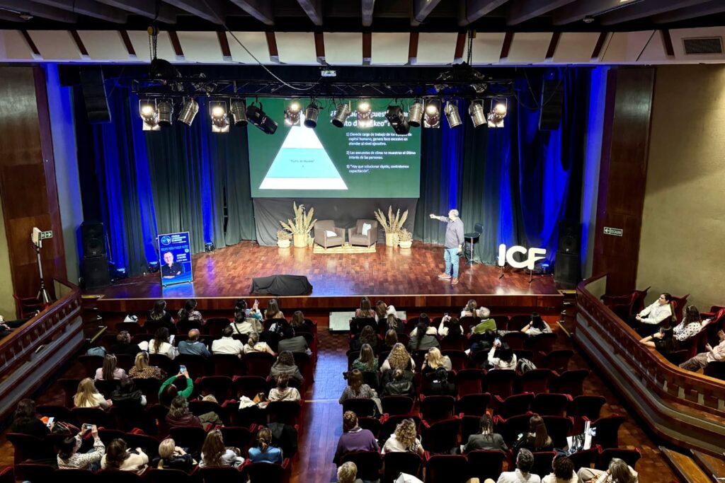Fotografía de Felipe Peña y Lillo ofreciendo una conferencia en un auditorio lleno, durante un evento organizado por ICF, con una presentación proyectada en pantalla sobre liderazgo y motivación.