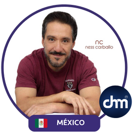 Fotografía de Ness Carballo con camiseta burdeos, posando de forma relajada con los brazos cruzados sobre una mesa blanca; incluye su nombre estilizado y un distintivo de México.