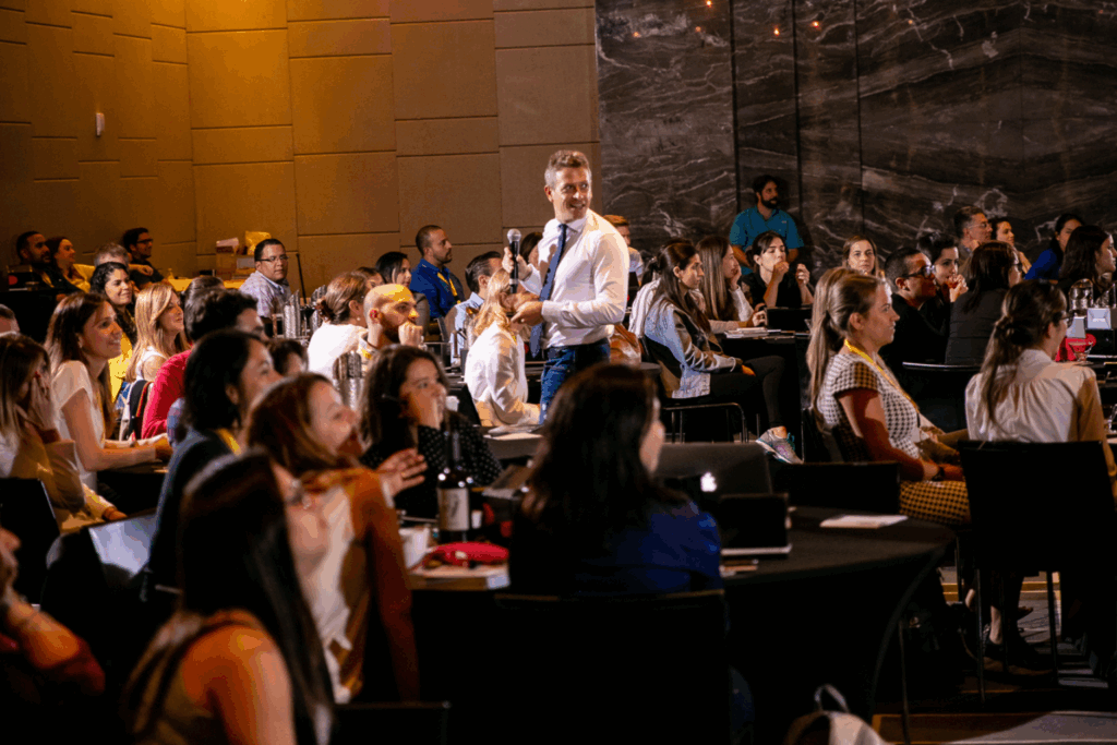 Fotografía de Enric Company interactuando con la audiencia durante una conferencia en un salón amplio y moderno, rodeado de asistentes atentos y entusiastas.