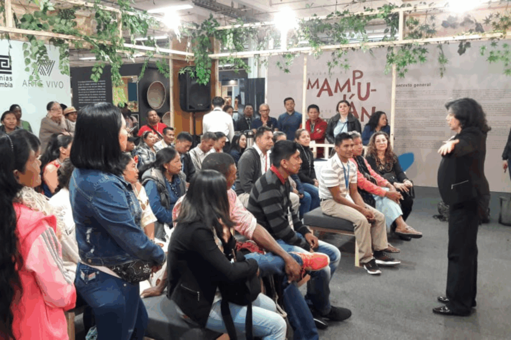 Fotografía de Lyda Ardila dictando una charla a un grupo de asistentes en un espacio cultural con decoración natural y ambiente participativo.
