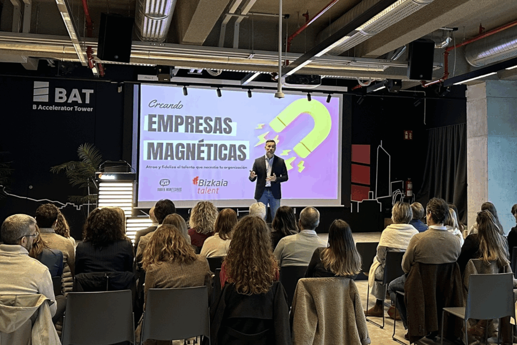 Fotografía de Rubén Montesinos en una conferencia titulada “Creando Empresas Magnéticas”, frente a un público atento en un auditorio moderno con pantalla y diseño industrial.
