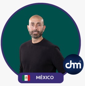 Fotografía de Anwar Buere, conferencista internacional, con fondo verde oscuro enmarcado en un círculo y etiqueta de “México” junto al logo de CHM. Viste suéter oscuro y muestra una expresión segura y accesible.