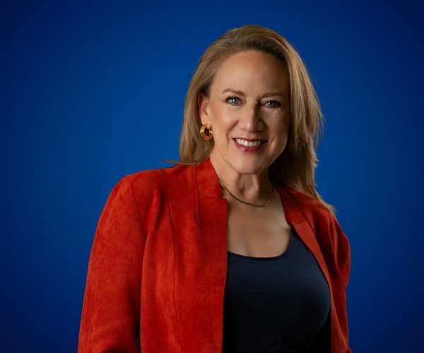 Fotografía de Paula Morelos Zaragoza, posando con una chaqueta roja sobre fondo azul sólido, con expresión segura y profesional.