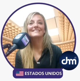 Fotografía de Gabriela Homenuc durante una entrevista radial, sonriendo frente a un micrófono en un estudio acústico, con ambientación cálida y sello de "Estados Unidos".